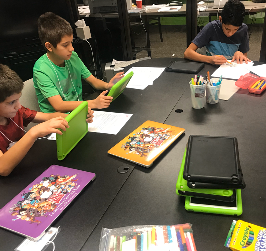 studentsat table using tablet and writing